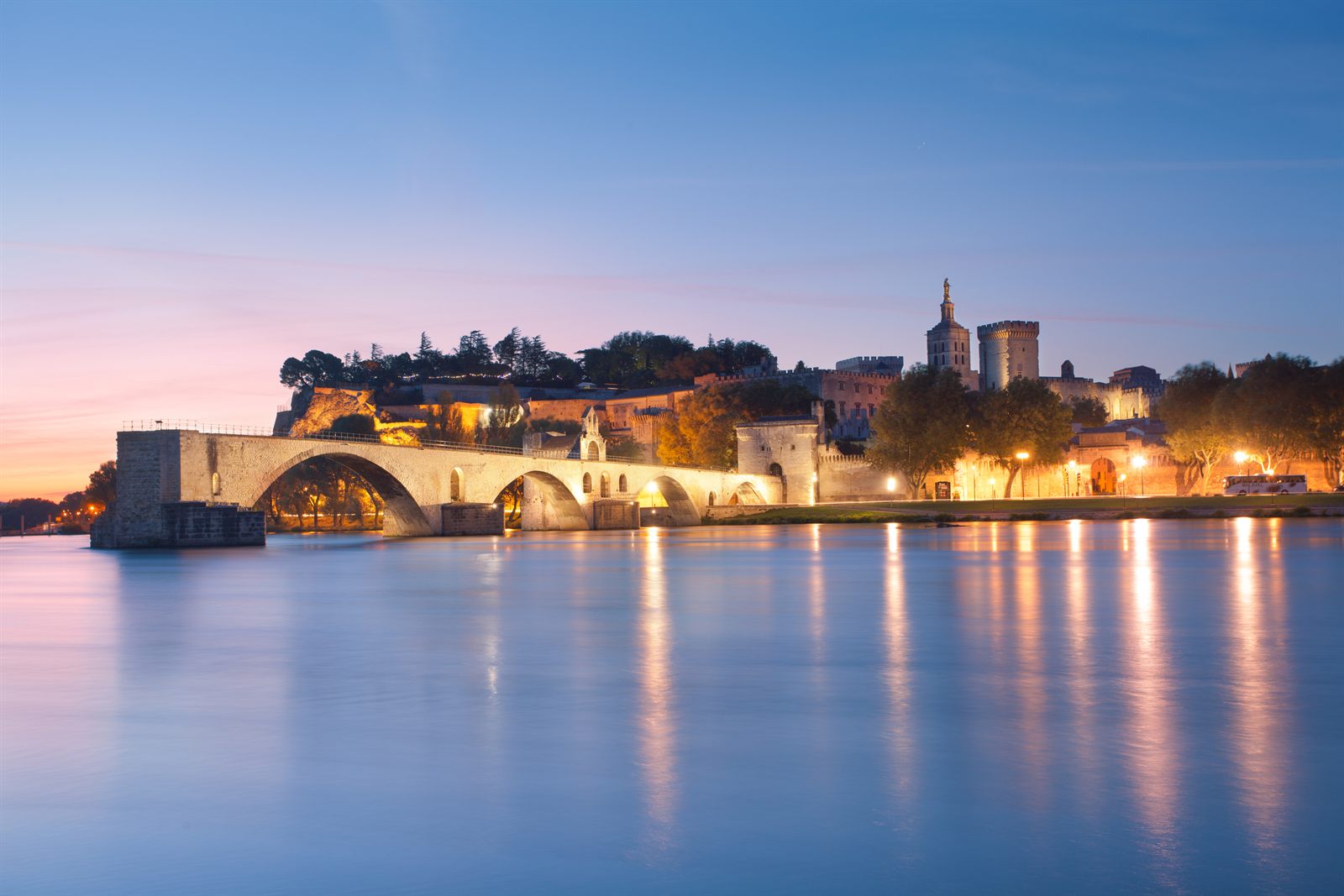 Pont d'Avignon and the Palace of the Popes reflected in the Rhône at dawn